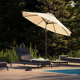 Utomhuslounge med svarta loungemöbler och sidobord vid en pool under ett stort parasoll i en grön nordisk trädgård från sackit