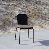 Svart Patio Chair no. One med grå sittdyna från sackit i nordisk utomhusmiljö med sand och strandgräs i bakgrunden