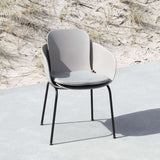 Grå sittdyna på en designad uteplatsstol från sackit i nordisk utomhusmiljö med sanddyner och gräs