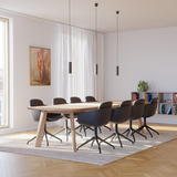 Modernt matrum med svart läderklädd sackit stol med snurrfunktion runt ett ljust matbord i nordisk och stilren inredning