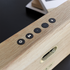 Närbild av trähögtalaren Move Wood från sackit med ekfaner och svarta kontrollknappar för ljud och uppspelning i stilren nordisk design