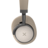 Beige over-ear-hörlurar från sackit med mjuka öronkåpor och diskret X-logotyp på sidan.