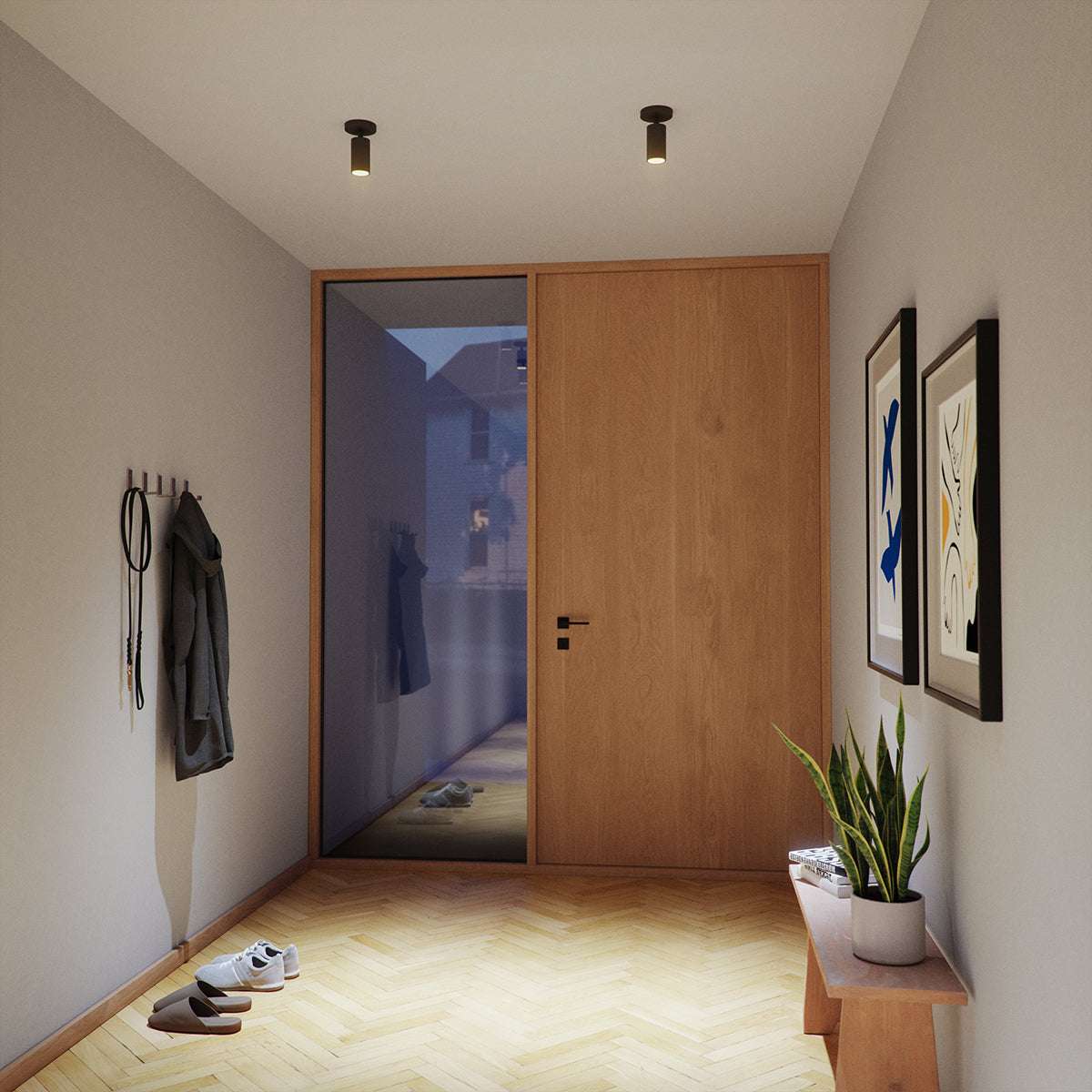 Modern hall med två svarta taklampor från sackit, träfärgad dörr, fiskbensparkett, väggkonst och gröna växter i nordisk inredning