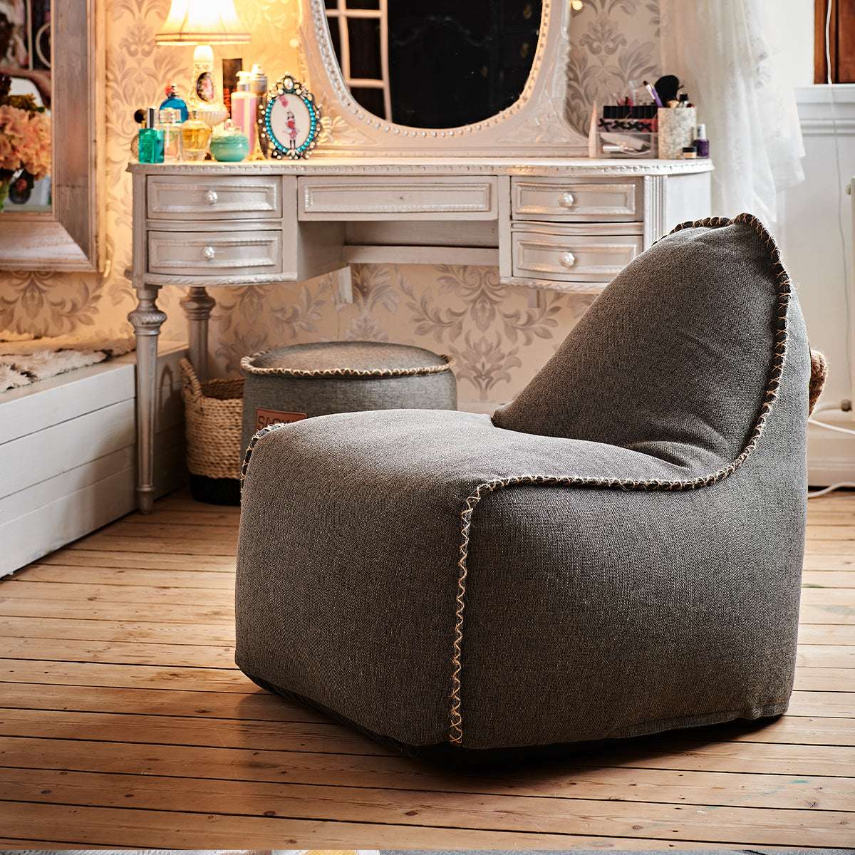Grå mjuk loungefåtölj med dekorativa sömmar i elegant sovrumsmiljö från sackit för bekväm avkoppling inomhus