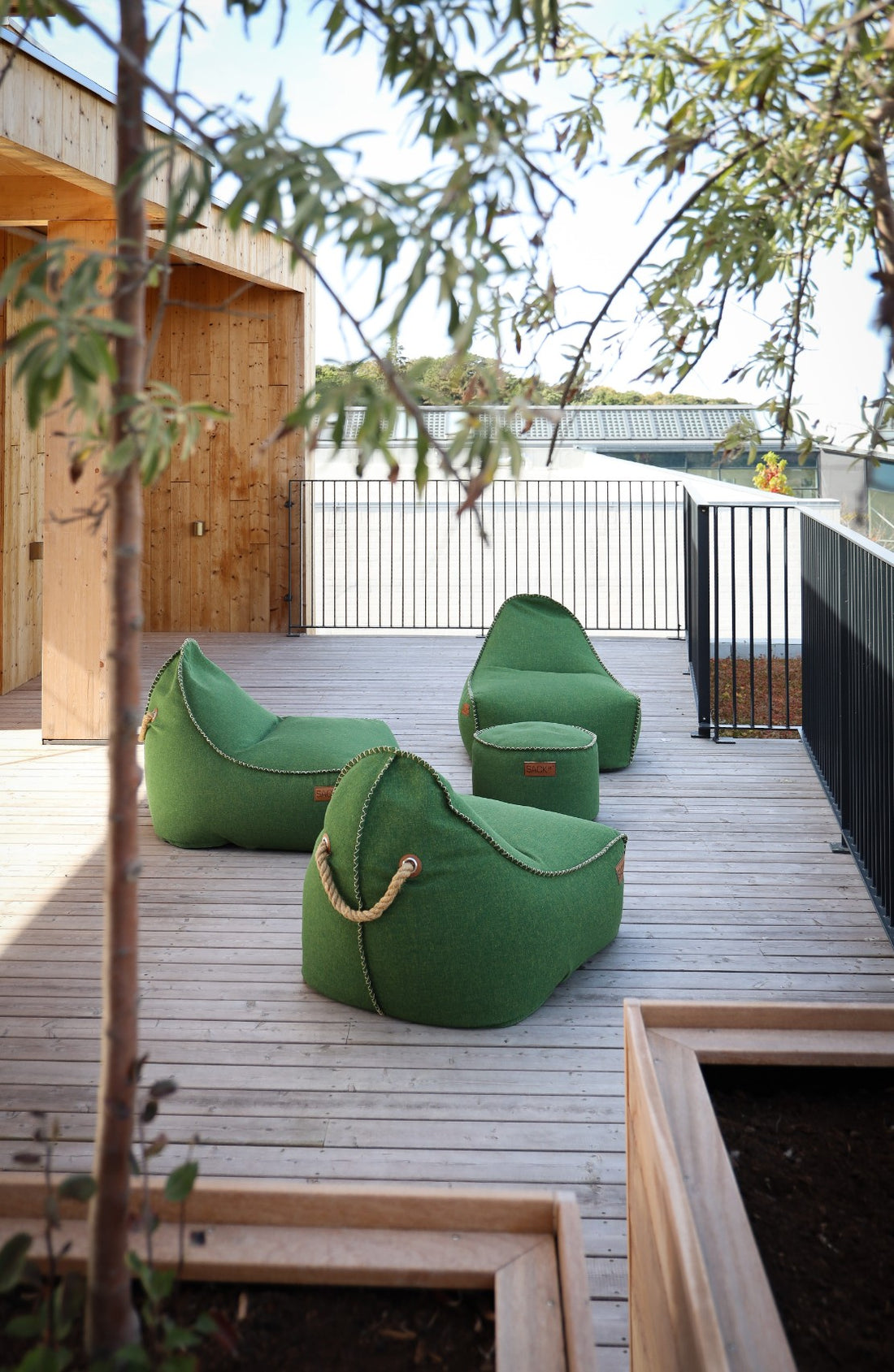 Loungeområde med flera gröna Cobana Lounge Chairs och Puffar från SACKit på Hotel GSH